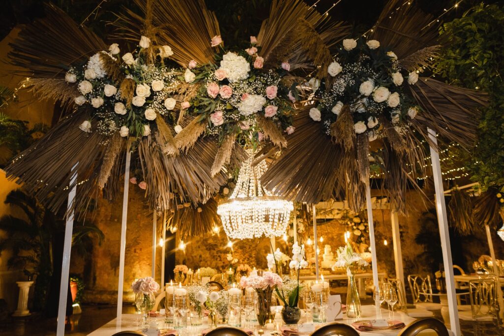 Centro de mesa colgante para boda con hojas secas, rosas blancas y rosadas, lámpara de cristal en cascada y decoración romántica con velas