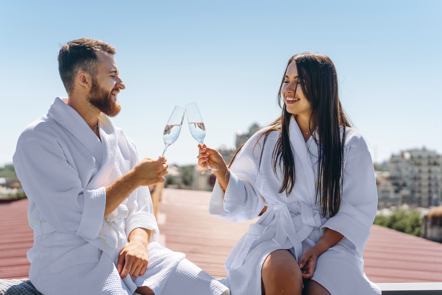 De Cabo Verde a Filipinas: los 7 destinos más populares para una luna de miel inolvidable playa romántica, flirting couple with sparkling wine on a roof, close angle